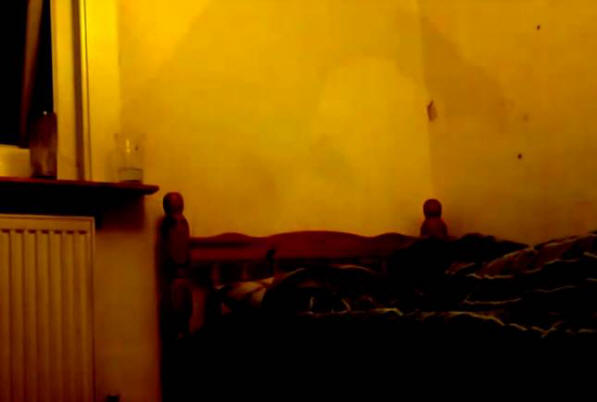 Moški je posnel megleno senco na kamero na čelu njegove postelje.