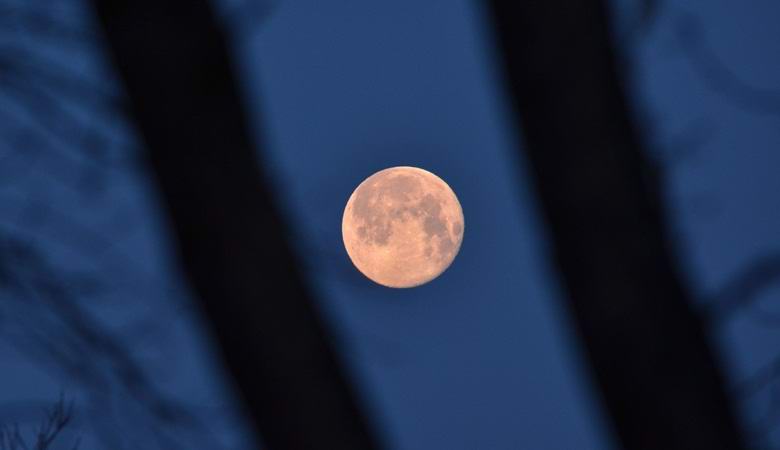 Na ozadju lune je visel nerazumljiv temen predmet.