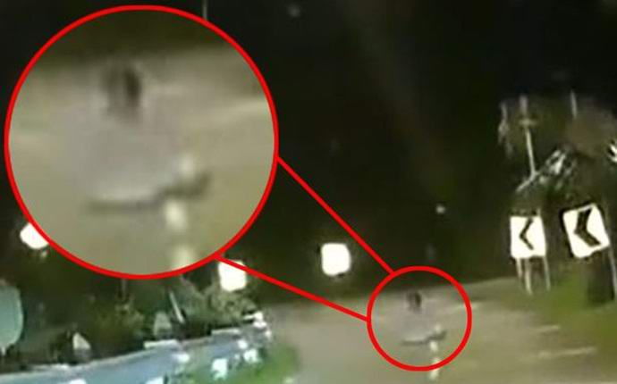 Duh sedi v položaju lotosa na nočni cesti.